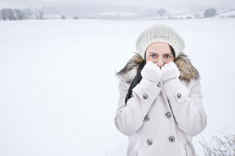 young woman dressed warmly standing in cold snow