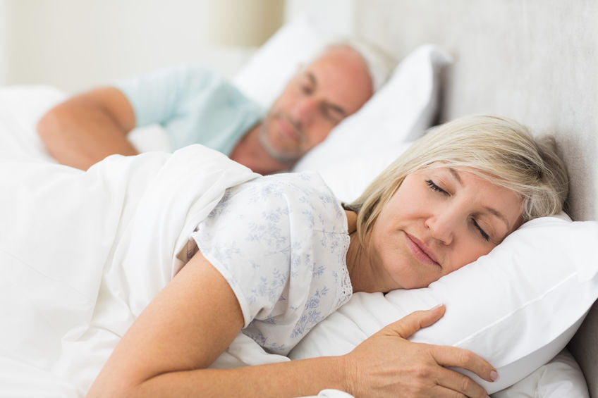 middle aged couple sleeping in bed
