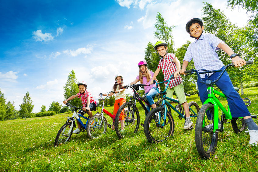 kids on bikes in a green field