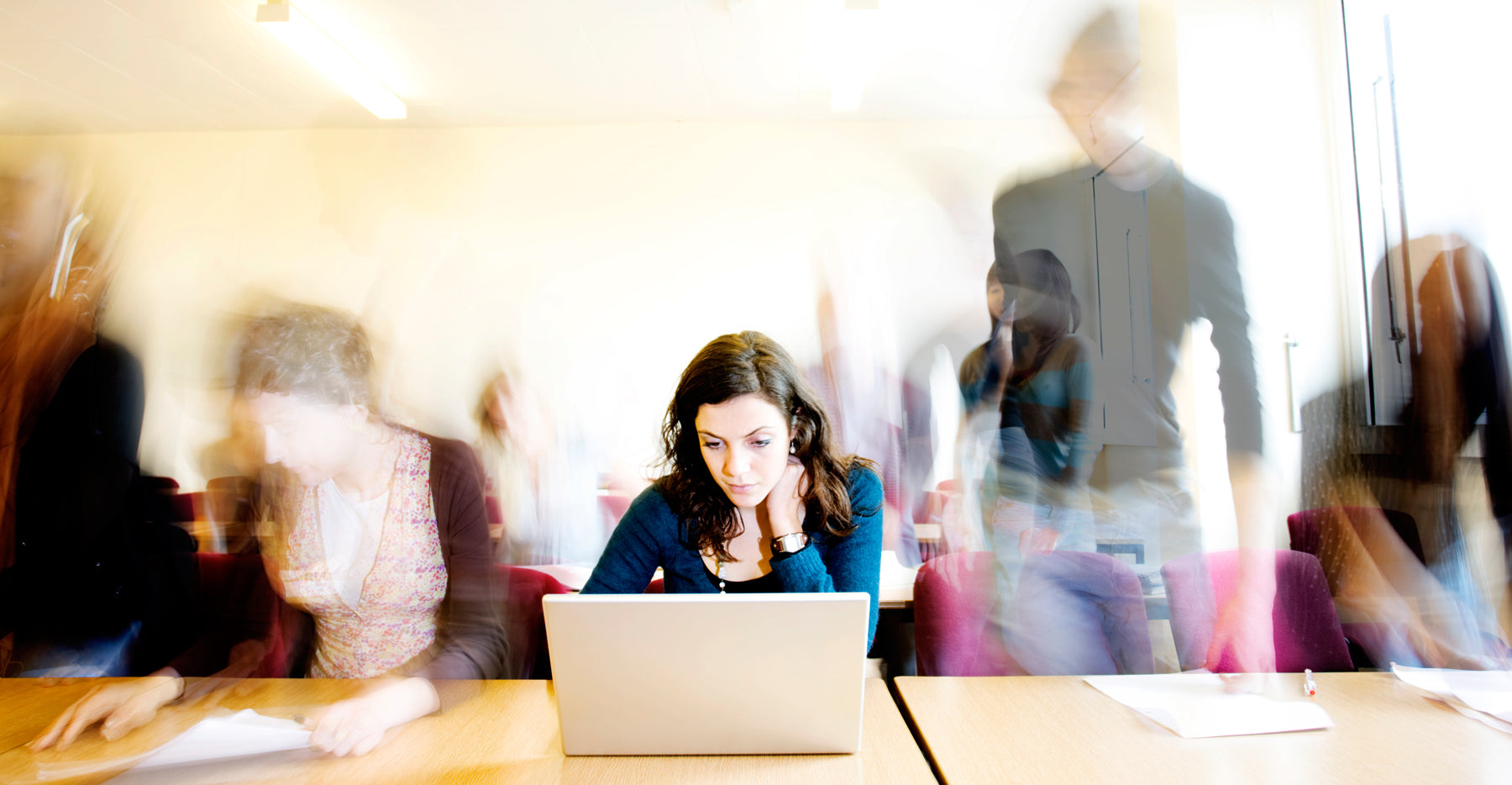 young woman at work reading from her laptop