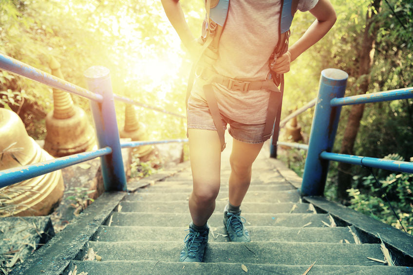 hiker walking up stairs with sun in background
