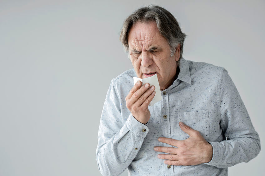 middle aged man sneezing and coughing