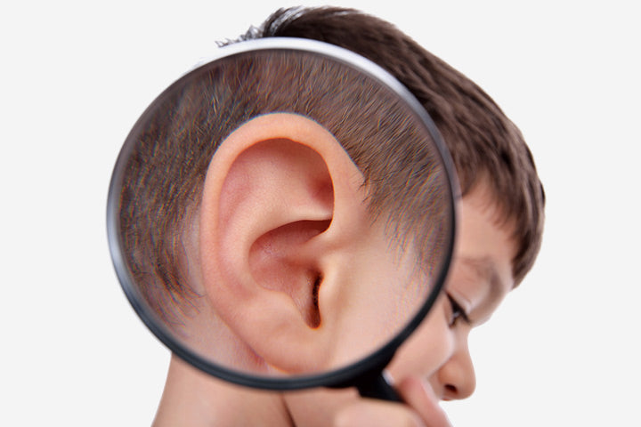 a magnifying glass focused on a young child's ear