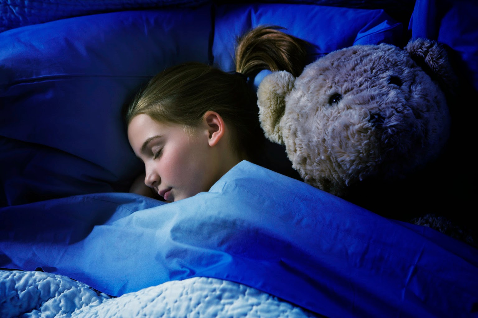 young girl sleeping in bed