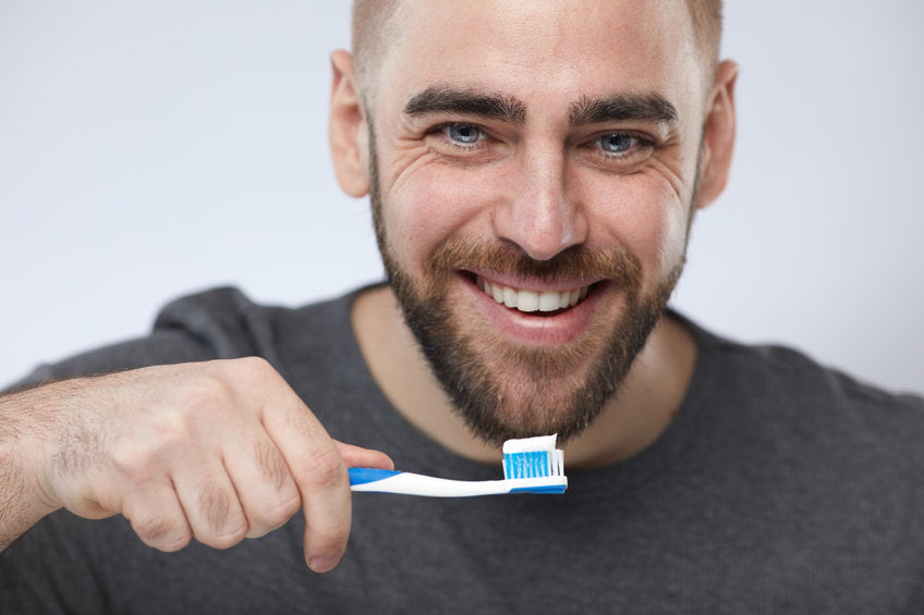 young man with toothpaste on toothbrush