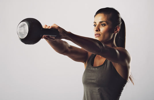 woman exercising with cow bell weight