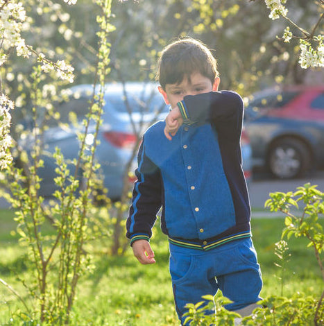 little boy wiping his nose