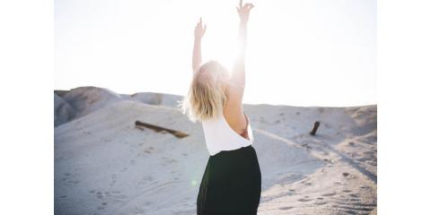 woman raising arms to the sun