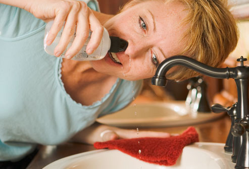 woman cleaning nose with nasal wash