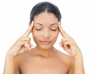 young woman performing acupressure on her forehead