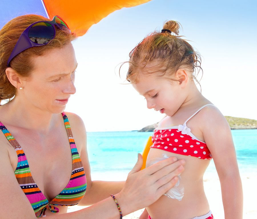 mother putting sunscreen on child