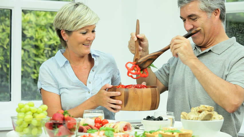 middle aged couple making salad